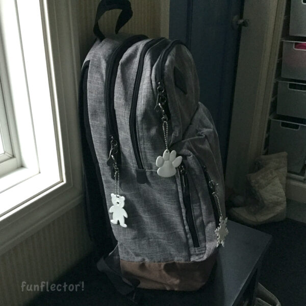 Backpack with white paw print, bear and snowflake safety reflectors by funflector