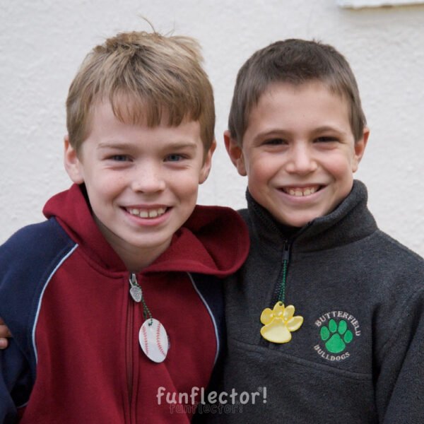 Boys with baseball and paw print safety reflectors for walking in the dark - by funflector