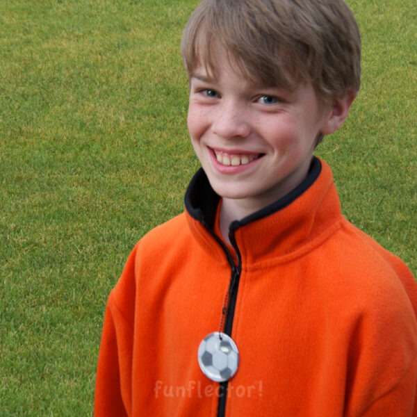 Boy with soccer ball safety reflector on his sweater zipper pull