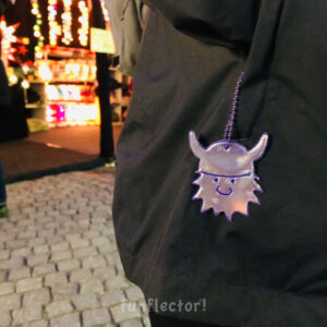 Purple viking safety reflector on jacket pocket zipper pull