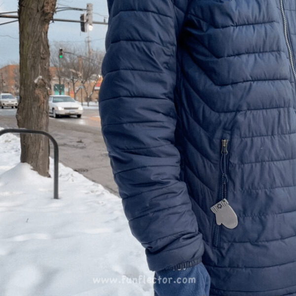 Black mitten safety reflector on dark blue winter jacket