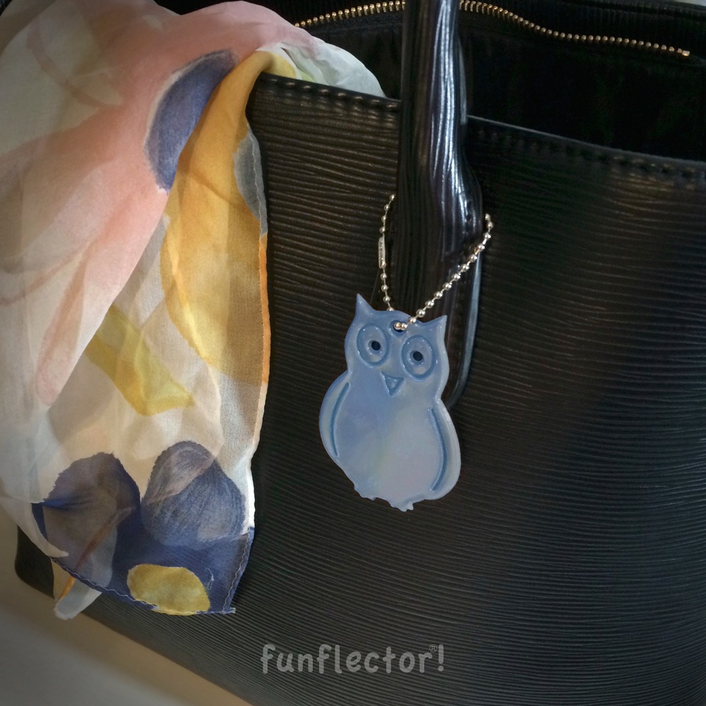 Blue owl safety reflector on black bag by funflector