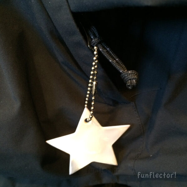 White star safety reflector on jacket pocket zipper pull