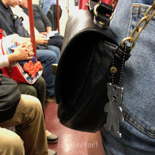 Teddybear safety reflector on a purse in the London tube