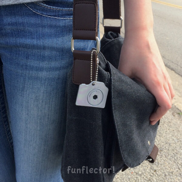 Silver camera safety reflector on messenger bag