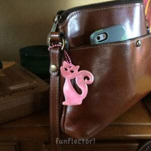 Pink cat safety reflector on brown purse