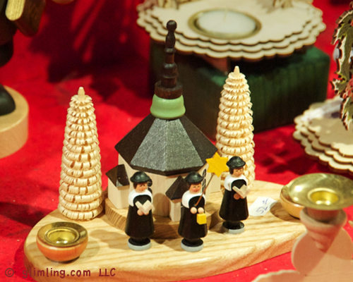 Handcrafted German wooden choir boys with typical curled wood trees and a chapel.