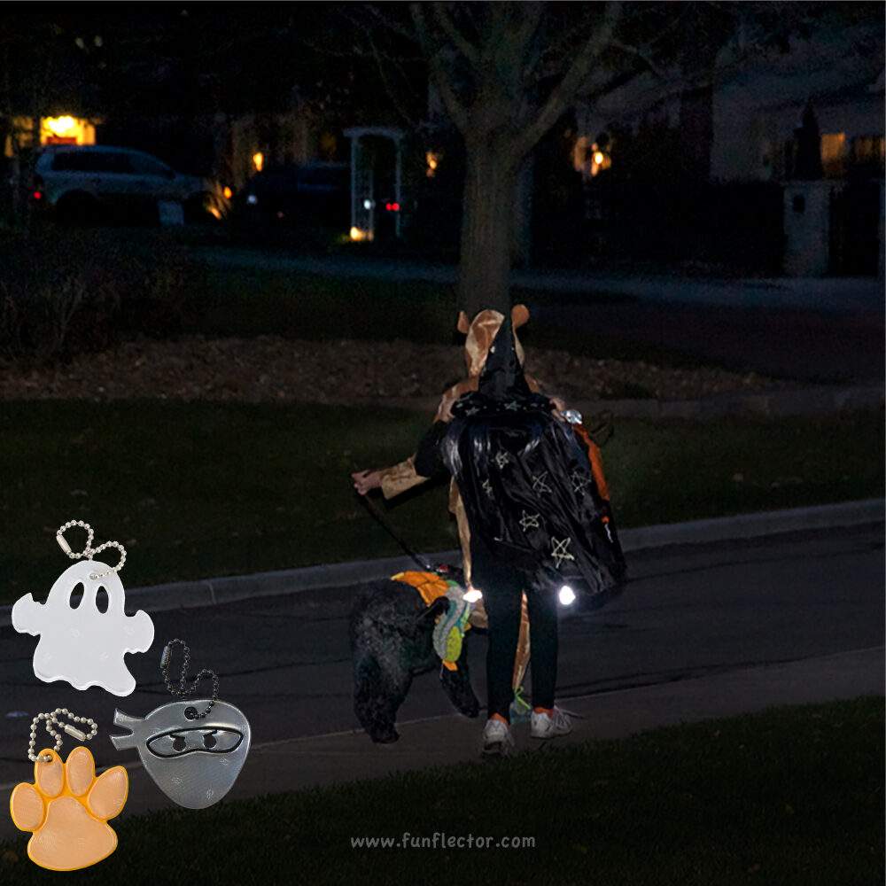 Dog and kids trick-or-treating in the neighborhood wearing halloween costumes and safety reflectors