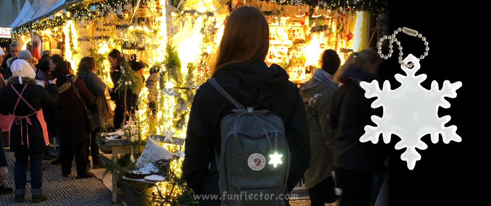 Visiting a German Christmas market in Berlin, wearing a snowflake safety reflector.