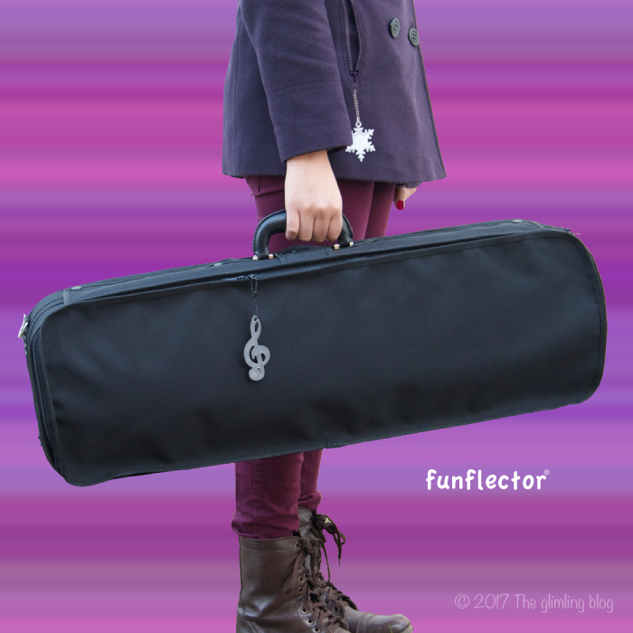 Treble clef and snowflake safety reflector on instrument case by funflector