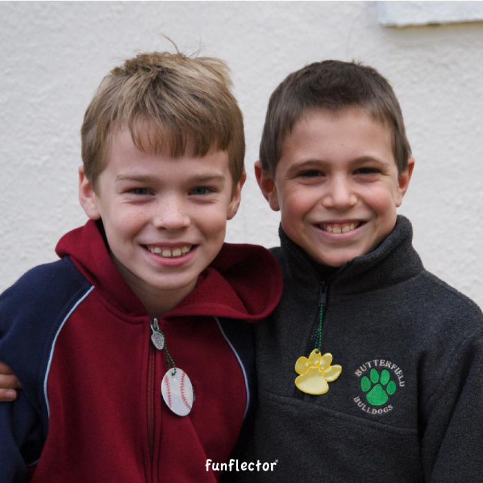 two boys with baseball and paw print safety reflectors